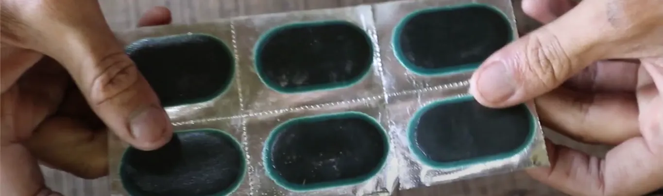 Proses menempelkan cold-patch pada bagian dalam ban tubeless yang bocor.